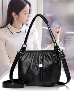Detail of black soft leather bucket bag featuring front zipper with silver pendant
