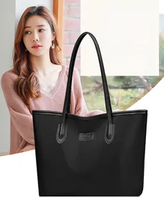 Dettaglio della grande borsa tote nera con la toppa logo Nice Fashion impressa a caldo