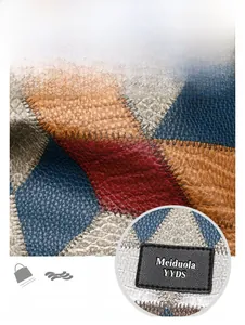 Close-up of pebble leather patchwork texture with blue, yellow, and red geometric panels