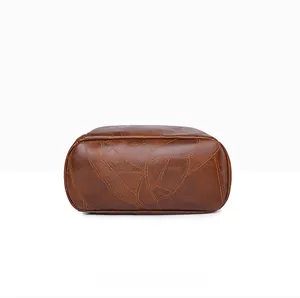 Close-up of vintage brown PU leather backpack bottom with detailed curved stitching