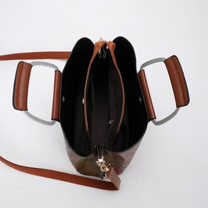Detail view of brown floral embossed tote bag with three compartments and metal handles