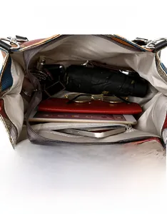 Macro detail of the spacious interior of the color-block tote bag with a zipper pocket