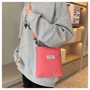 Vue détaillée du petit sac bandoulière matelassé rose avec sangle et étiquette mode