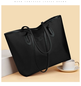 Dettaglio della borsa tote in nylon nero con logo NICE e manici in pelle resistenti