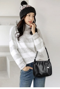 Black soft PU leather shoulder bag with side zipper and lock pendant on a female model