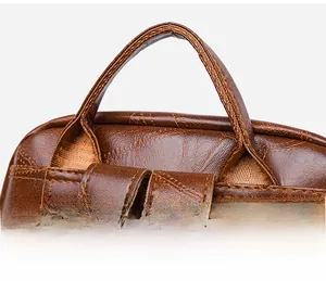 Close-up of the reinforced stitching and soft PU leather handle on the brown backpack