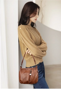 Detail of vintage brown soft PU leather bucket bag featuring a vertical front zipper pocket