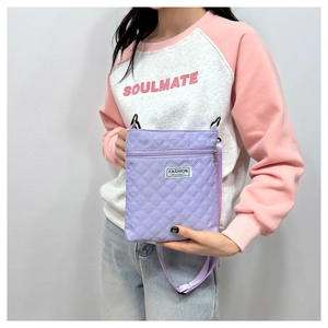 Vue détaillée du sac bandoulière lilas matelassé avec surpiqûres en losange et logo noir