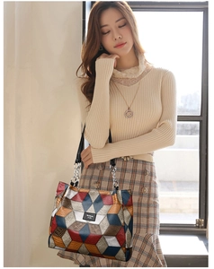 Detail of colorful geometric patchwork tote bag with metallic chain and black handles