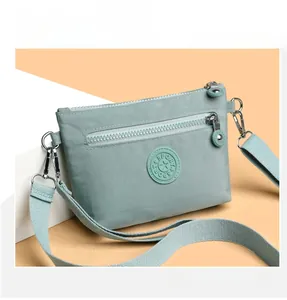Detailansicht der mintgrünen Umhängetasche aus Nylon mit Logo und silberner Metallschnalle