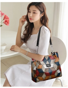 Detail of colorful geometric tote bag with embossed leather and metal chain strap