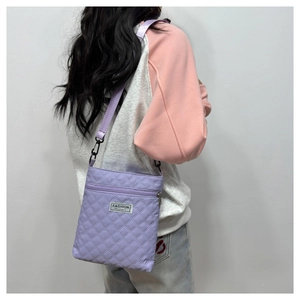 Détail du sac à bandoulière matelassé violet avec étiquette tissée fashion instinct
