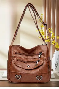 Detail view of dark brown faux leather crossbody bag with multiple zipper pockets