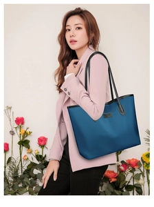 Dettaglio della borsa tote in nylon blu con trama fine e spalline in pelle nera di qualità