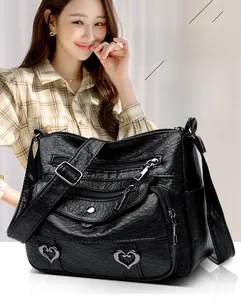 Asian woman wearing a black multi-pocket crossbody bag with soft lychee leather texture