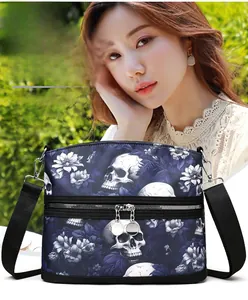 Detail of navy shoulder bag featuring skull and floral prints with silver metal zippers
