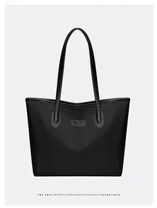 Dettaglio della borsa tote in tessuto oxford nero con manici lunghi e toppa NICE