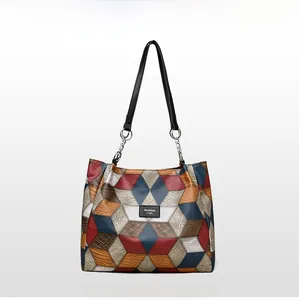 Close-up of a color-block geometric tote bag with black handles and metal ring accents