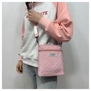 Détail d'un sac bandoulière rose matelassé avec motif à losanges et sangle ajustable
