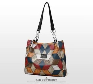Close-up of geometric color-block tote bag with textured leather and metal chain straps
