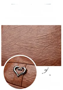 Close-up of dark brown lychee texture leather with heart-shaped silver metal buckle