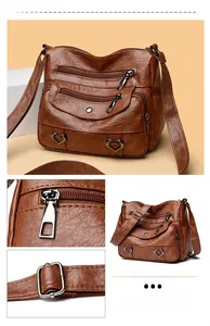 Detail view of multi-pocket crossbody bag with vintage brown leather and heart hardware