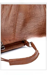 Detail of brown PU leather texture and thick reinforced handle with precision stitching