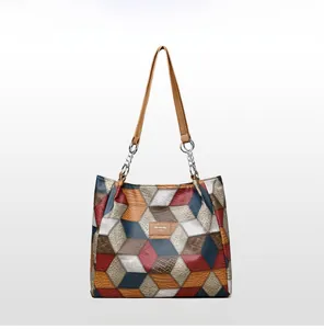 Detail view of large tote bag featuring geometric color block panels and chain handles