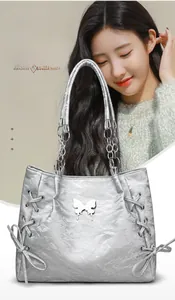 Close-up of silver tote bag featuring metallic texture and knotted bow ribbon details