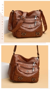 Detailed macro view of the brown soft leather texture and multiple zipper pockets on a crossbody bag