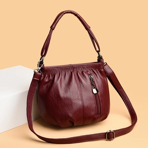 Detail view of burgundy soft PU leather texture with elegant pleats and vertical zipper