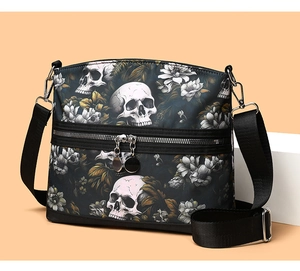 Detail of skull print crossbody bag with dual silver zippers and wide nylon strap