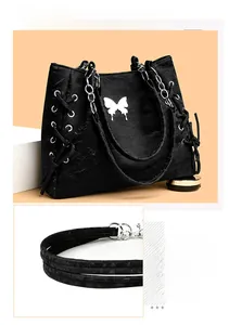 Detail of silver butterfly buckle and lace-up design on a black leather tote bag