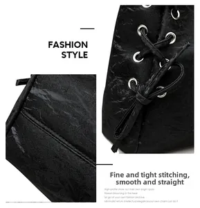 Detail showing precise stitching and drawstring design on black textured leather bag
