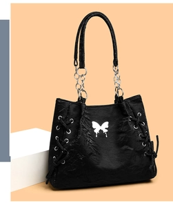 Detail of black Y2K tote bag with white butterfly motif and silver metal chain strap