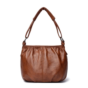 Detail of soft brown PU leather bucket bag with pleated texture and metal D-ring buckle