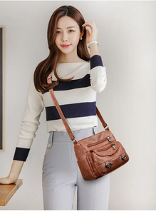 Brown faux leather crossbody bag with multiple zip pockets shown on a person
