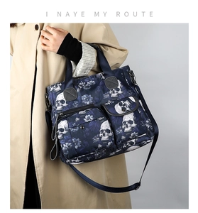 Macro detail of skull and floral printed tote bag with functional zippers and pockets