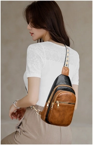 Detail of vintage crossbody bag showing multi-zip pockets and patterned strap