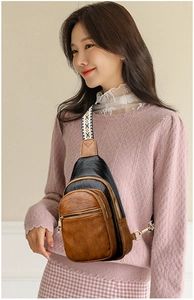 Detail view of vintage multi-compartment crossbody chest bag with geometric woven strap