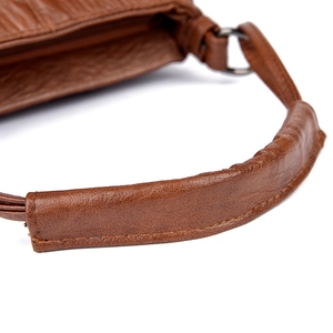 Detail of brown litchi pattern PU leather bucket bag with top zipper and stitched handle