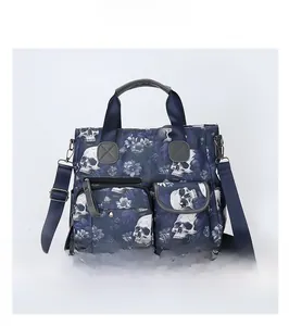 Detail view of navy skull floral tote bag with front pockets and adjustable strap