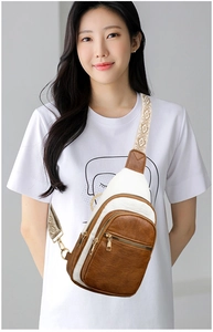 Detail of crossbody bag featuring brown and white PU leather with ethnic style strap
