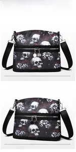 Detail of gothic skull and floral print on black crossbody bag with dual zipper compartments