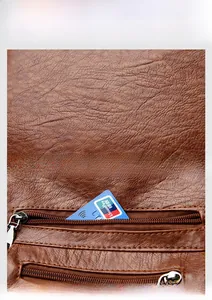 Detail of brown leather texture and functional front zipper pockets for card storage