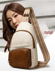 Detail view of leather crossbody chest bag with geometric pattern woven shoulder strap