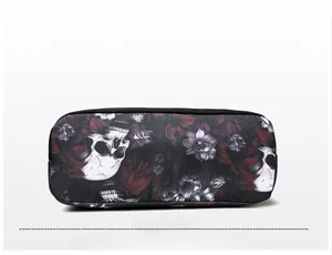 Detailed bottom view of crossbody bag featuring gothic skull and floral print canvas