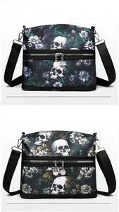 Close-up of gothic skull and floral prints on black crossbody bags with dual zip pockets
