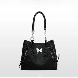 Detail of black tote bag with white butterfly print and silver metal chain strap handles