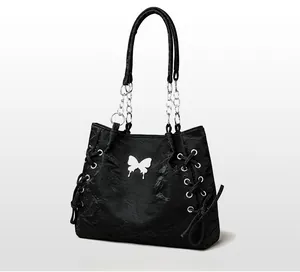 Detail of black tote bag featuring textured pleated material and white butterfly patch